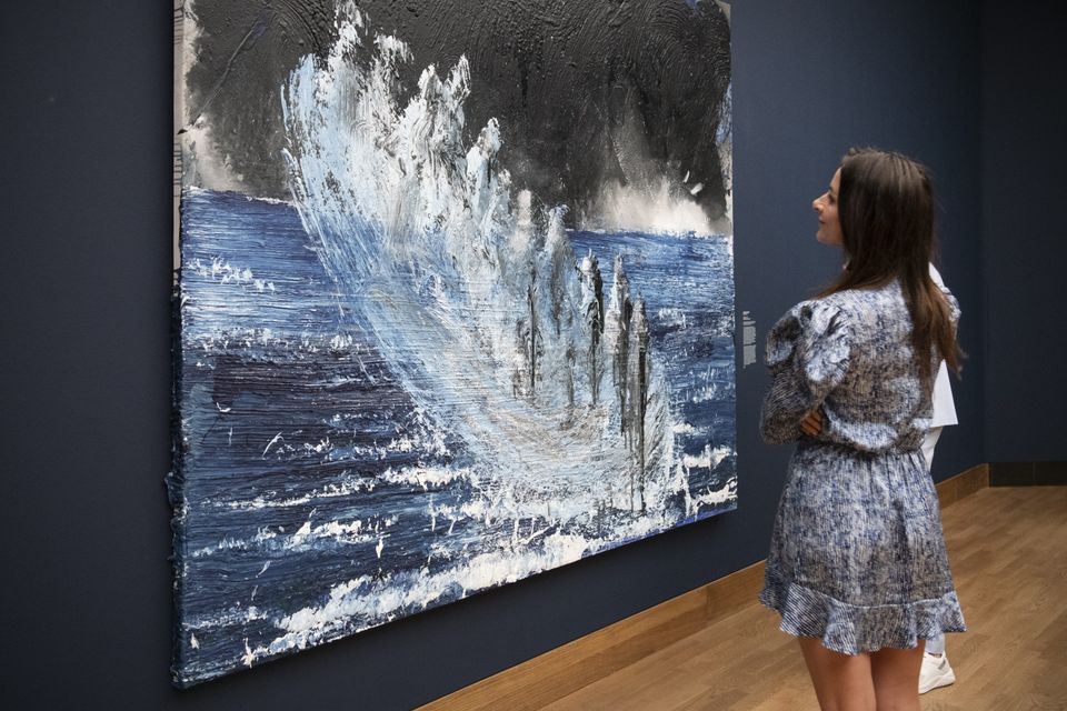 Vrouw kijkt naar groot kunstwerk in tentoonstelling La Grande Bleue