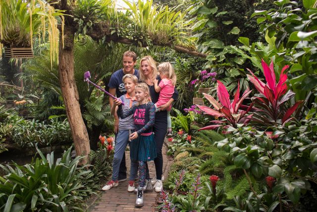 Een gezin bestaande uit vader moeder en drie kinderen maakt samen een selfie in een tuin van De Orchideeën Hoeve in Luttelgeest in de Noordoostpolder.