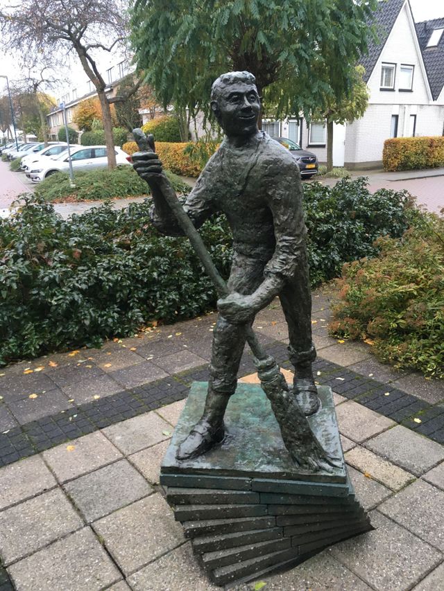 Kunstwerk Straatveger van Gerard van Steenbergen. Zijn bronzen gezicht glimlacht breed naar je. Bijzonder is dat hij met zijn hoofd op dezelfde hoogte zit als de gemiddelde 
kijker.