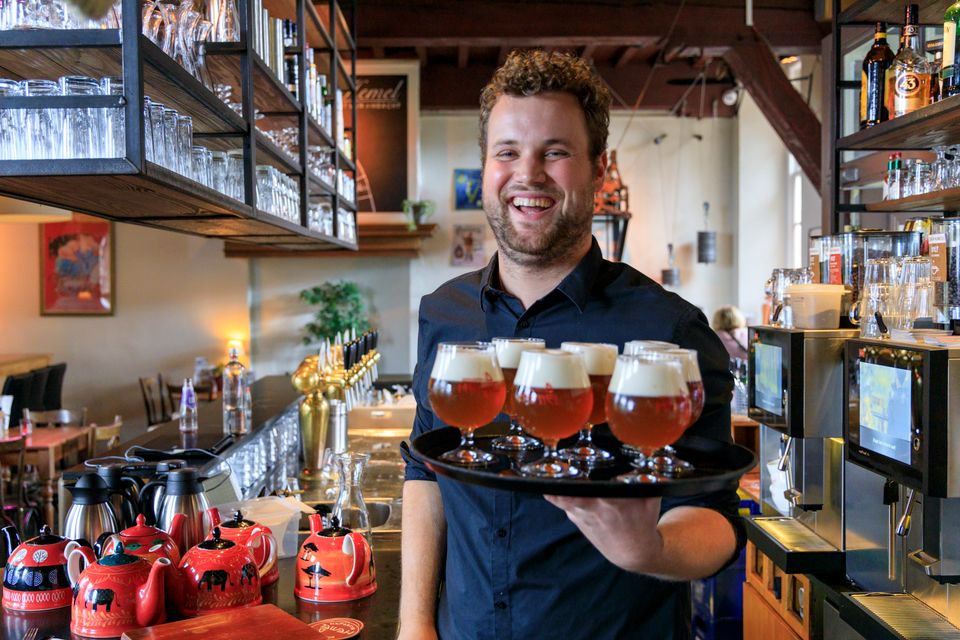 Barman met dienblad bier bij restaurant De Pelgrim in Nijmegen