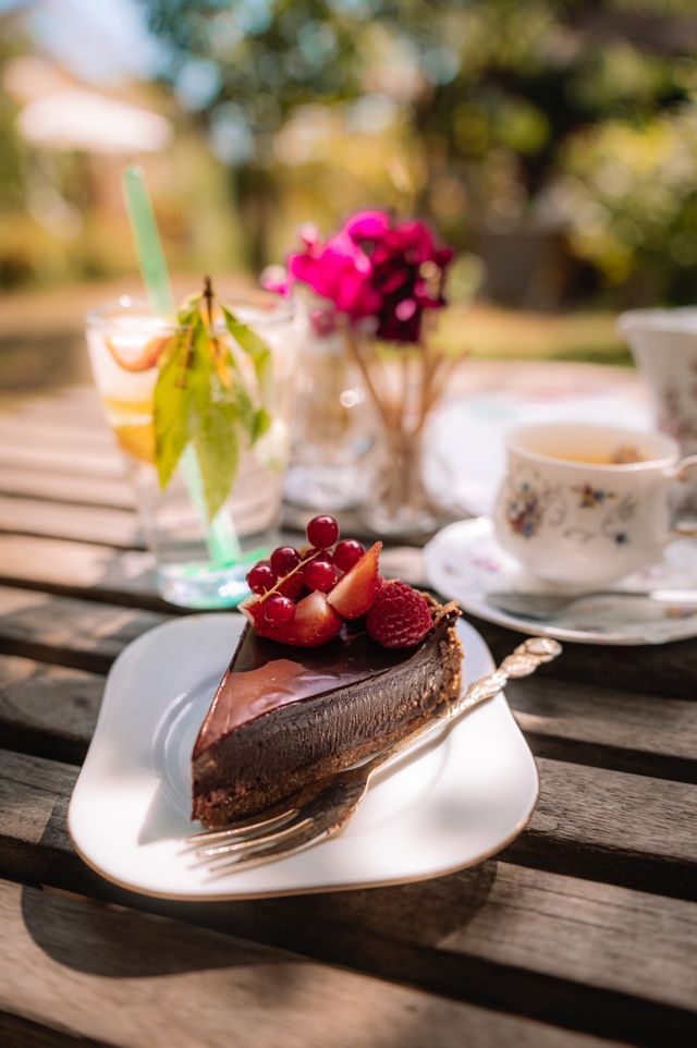 Kopje thee en zelfgemaakte taart in de tuin bij Theetuin de Wilde framboos