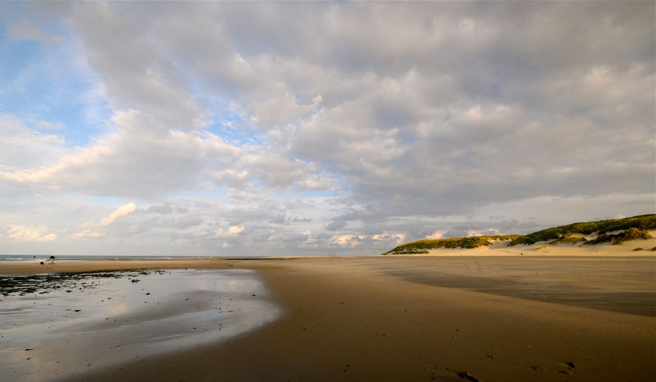 Vlieland donker strand nat en gele duinen grijze lucht met blauw