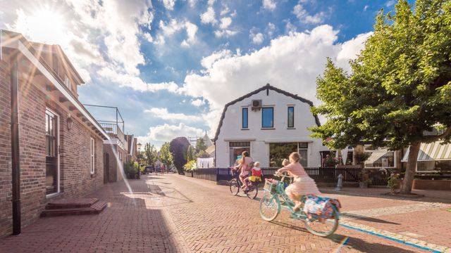Woningen in een dorp waar kinderen fietsen in Urk, Flevoland