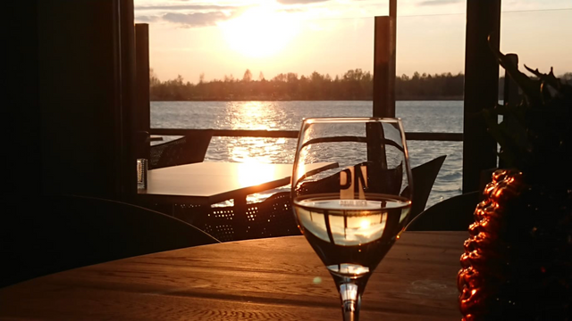 Een glas wijn op het terras met ondergaande zon