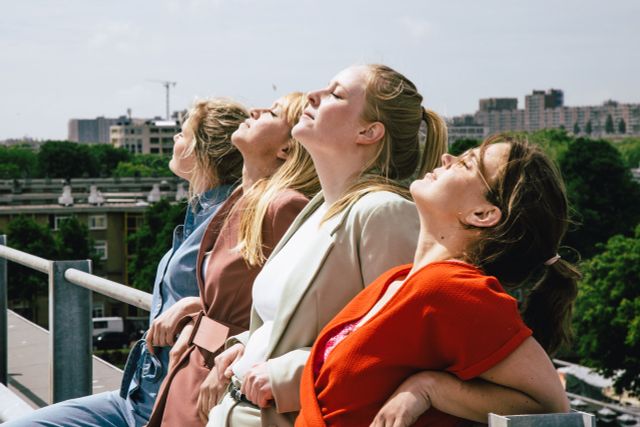 Vier vrouwen zonnen op een dak