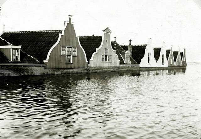 Zwart-wit foto van de Watersnoodramp in Volendam. Huizen staan voor de helft onder water door de dijkdoorbraak.